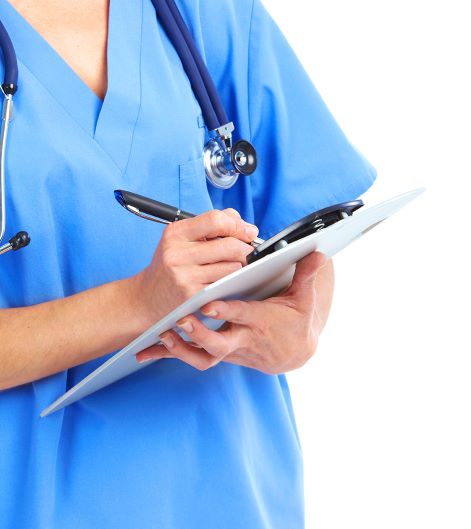Doctor in blue scrubs with stethoscope around his neck is writing something down on a clipboard. - quartzclinical